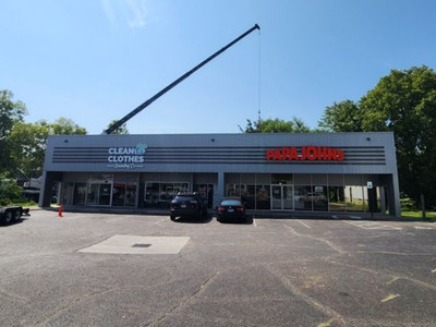 Crane removal service lifting large tree section at commercial property in St. Louis area