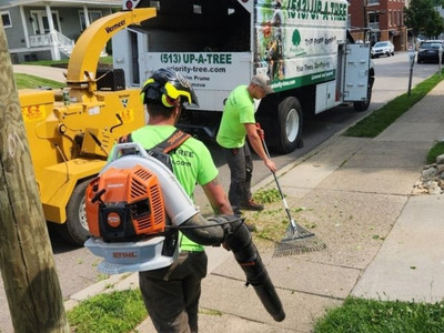 Priority Tree crew member operating wood chipper truck during tree removal cleanup